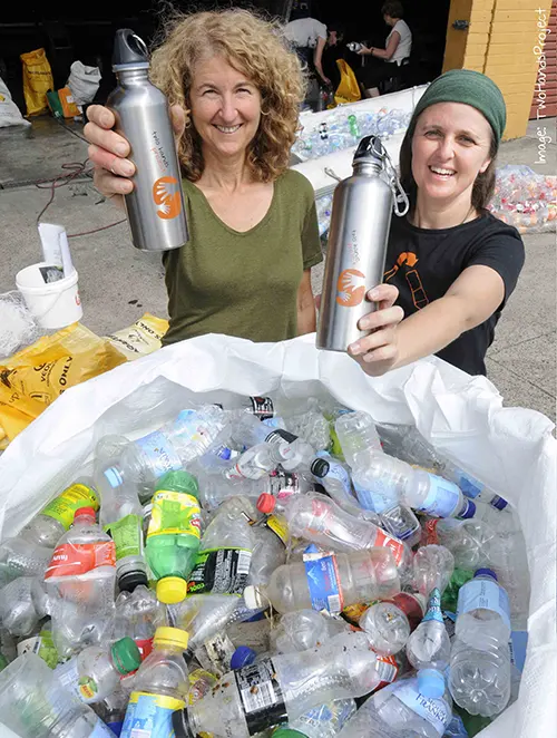 Women holding custom printed aluminum water bottles encouraging environmental responsibility and reducing single use plastic