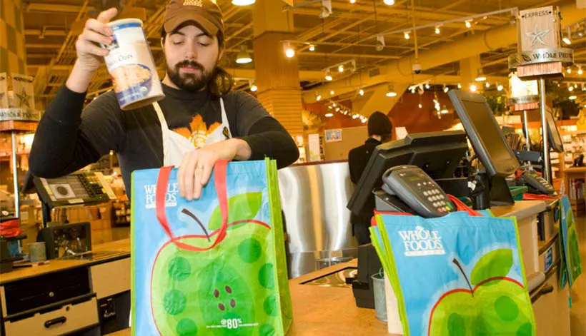 Grocery store check out clerk bag and groceries and reusable grocery shopping bags