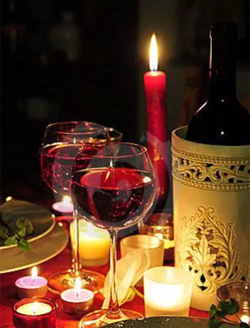 Wine glasses sitting on table with meal and candles