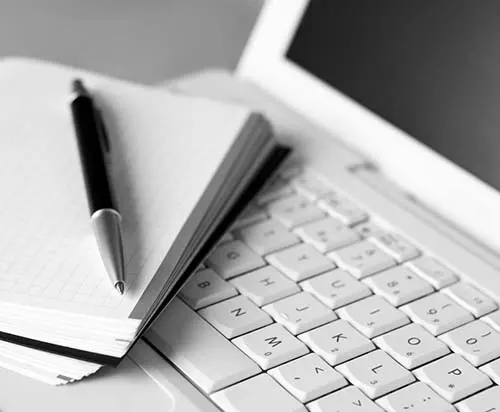 Pen paper and laptop in black-and-white