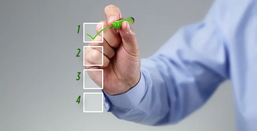 Hand holding a marker checking of item on checklist.