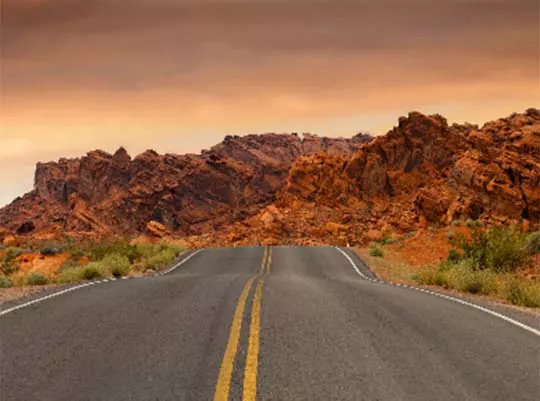 Highway in the American Southwest with red rock formations