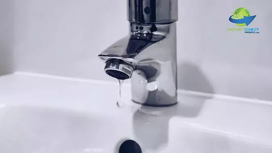 Drip coming out of water faucet into white porcelain sink