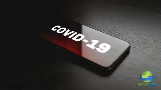 COVID-19 displayed on screen of digital device in low light setting