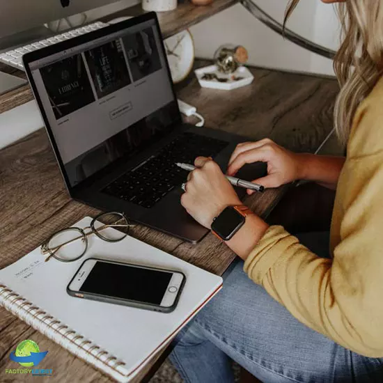 Work-from-home employee at desk with laptop, notepad, and cell phone