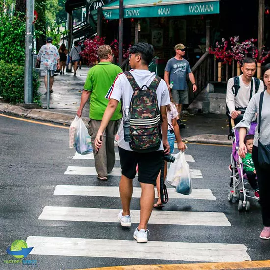 Pedestrians walking in crosswalk carrying grocery bags